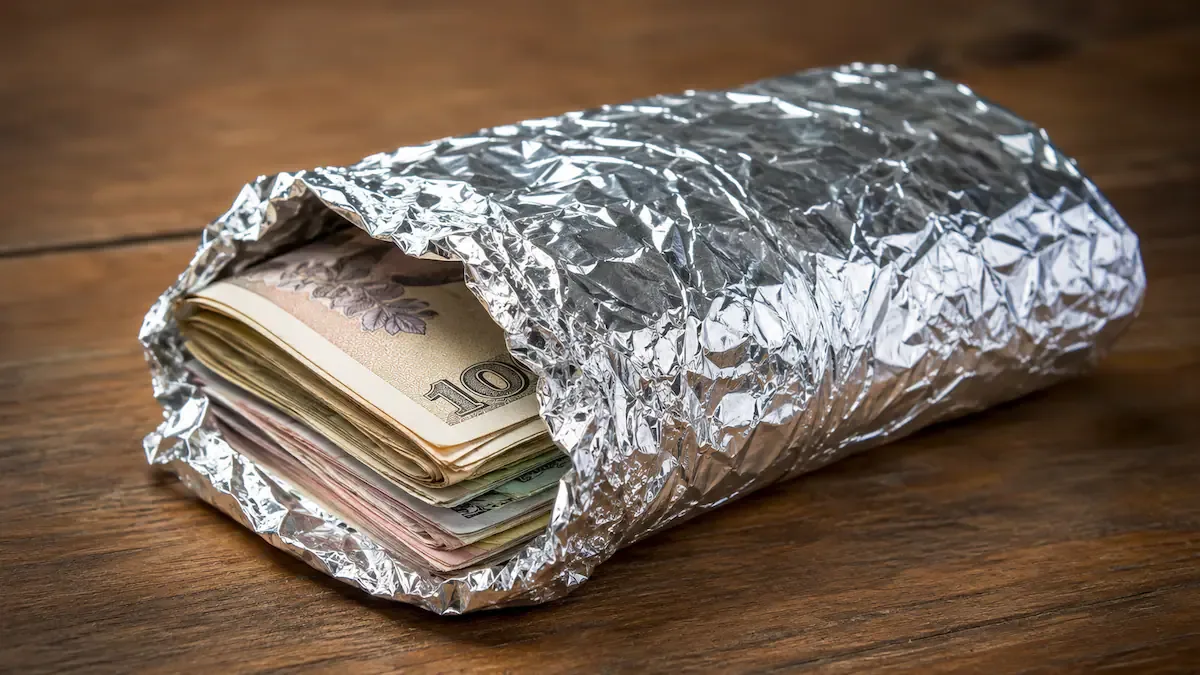 Envolver el dinero en efectivo en papel aluminio: para qué sirve y por qué recomiendan hacerlo (Representación creada con IA)