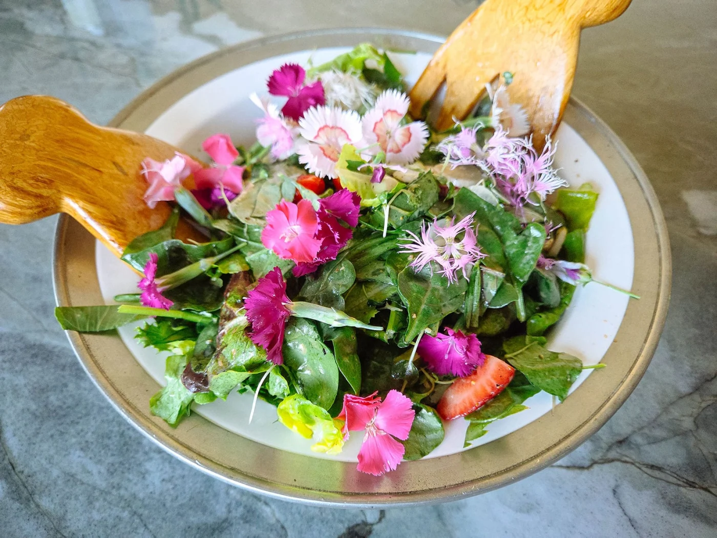 Garden salad with edible dianthus flowers
