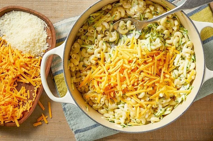 Raastettua kesäkurpitsaa ja juustoa lisätään kattilaan
