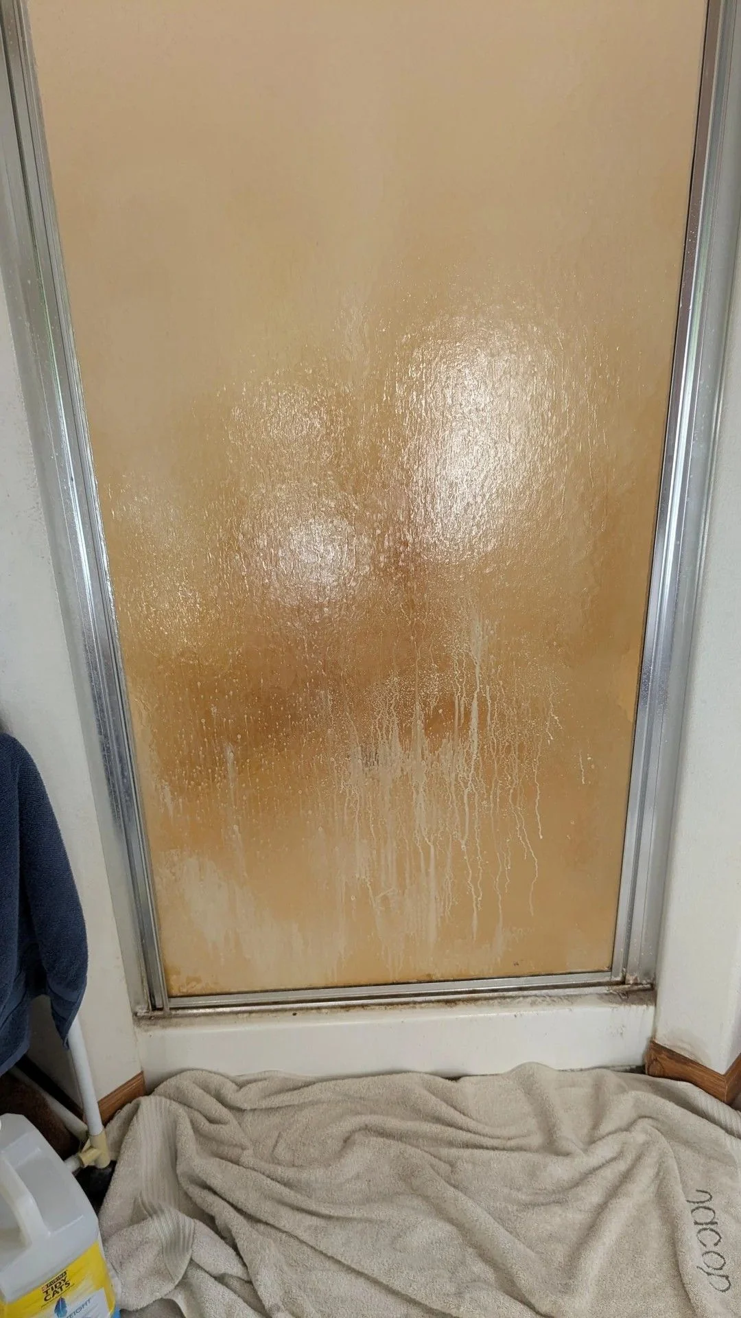 Yellow buildup covered the shower door